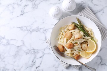 Delicious scallop pasta served on white marble table, top view. Space for text