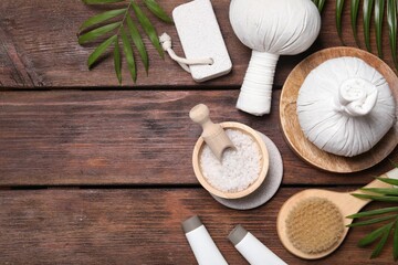 Flat lay composition with spa products and leaves on wooden table. Space for text
