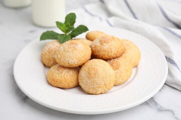 Tasty sweet sugar cookies and mint on white marble table, closeup