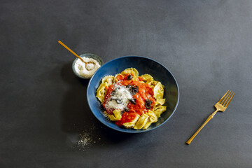 Photographing Italian pasta with tomato on a black surface