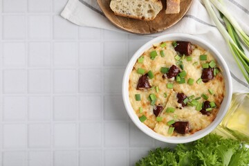 Tasty sausage casserole in baking dish served on white tiled table, flat lay. Space for text