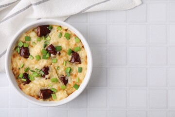 Tasty sausage casserole in baking dish on white tiled table, top view. Space for text