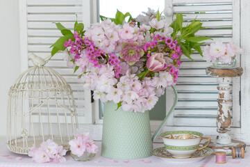 Arrangement mit Blumenstrauß mit Blüten der Japanischen Säulenkirsche, Lenzrose, Tulpe und Bergenie