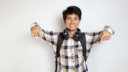 happy young asian man posing pointing down with both hands