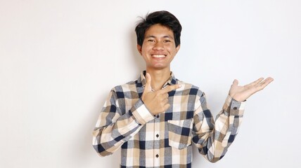happy young asian man posing pointing at his palm with an isolated white background