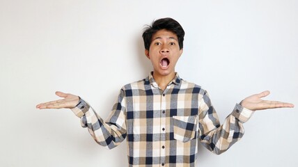 shocked young asian man posing showing both hands wide against