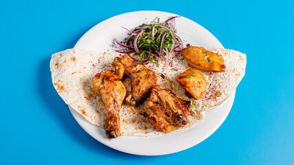 Chicken kebab on plate isolated on blue background