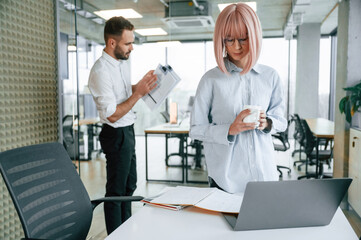 Fototapeta premium Dealing with documents. Man and woman are working in the office together