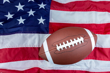 lay flat of brown leather football on strips and stripes of the American flag - obrazy, fototapety, plakaty
