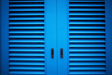 Pale blue closed metallic doors urban street background - 780680239
