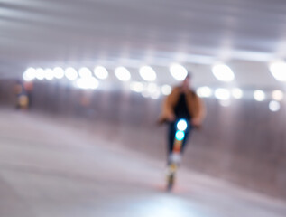 Scooter rider in city tunnel abstract bokeh background