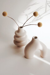 Modern beige ceramic vases set with dry  grass on beige background and sunlight shadow.Copy space, ...