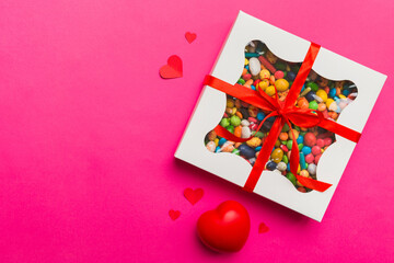 Valentine day composition: sweet candy, with gift boxes with bow and red felt hearts, photo...