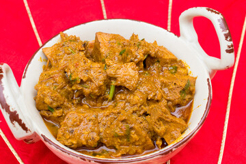Jackfruit curry or Kathal ki sabji in white dish and red background. selective focus