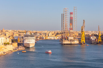 A large white tourist boat near the Valletta pier on a sunny morning. - 780693404