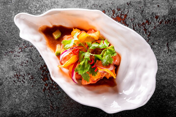 Vibrant gourmet dish showcasing culinary artistry, served in a unique shell-shaped plate. The plate is filled with fresh, colorful vegetables and herbs