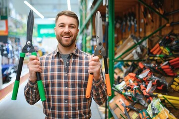 a customer chooses a garden shears for himself in a garden supply store