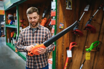 a young man in a gardening equipment store