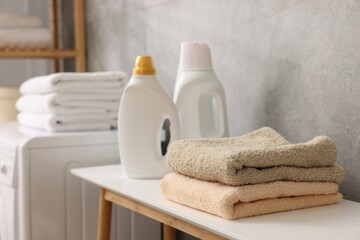Soft towels and detergents on bench indoors, closeup