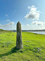 A stone post in green rolling hills on the Irish west coast.
