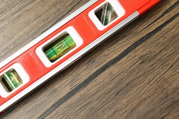 One red building level on wooden table