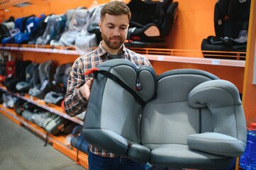 young male with car seat for kids in the children's store