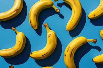  Ripe bananas arranged in a row on blue surface with shadow, fresh tropical fruit concept © SHOTPRIME STUDIO