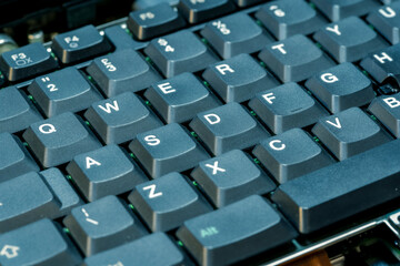 Old thick keys on a retro laptop computer keyboard soft blue green tint vintage detail shot, nobody, retro computing old technology aesthetics concept, no people. QWERTY keyboard up close, shallow DOF