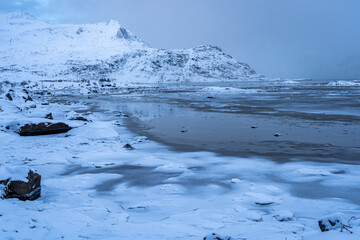 schneebedeckte Küste, Spiegelung von Berge im Meer bei Ebbe, Winter auf den Lofoten