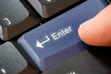 Man pressing a blue enter key on a laptop computer keyboard, hand finger object detail macro extreme closeup, confirmation abstract concept, taking, confirming an action, sending a message, one person