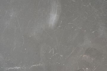 Close up view of scratches and marks on a flat light grey hard plastic material surface, plastic...