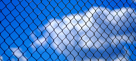 Chainlink Fence with Clouds and Sky in Background