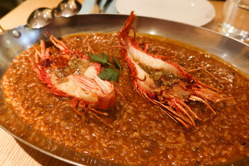 close up of shrimp prawn paella in a large iron plate