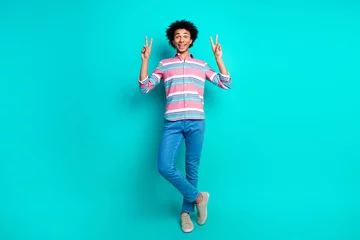  Photo of cheerful young man dressed stylish striped clothes v-sign isolated on cyan color background © deagreez
