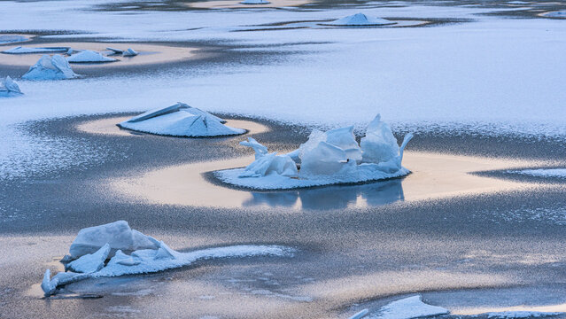 zugefrorenes Meer f&uuml;hrt bei Ebbe zu Eisskulpturen, gebrochenes Eis spiegelt sich in zugefrorenem Meer