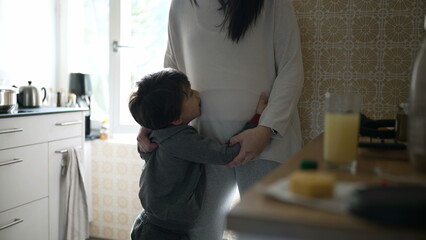 Affectionate Embrace in the Kitchen - Young Boy Seeking Hug from Mom, Heartwarming Family...