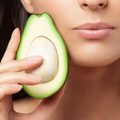 Half cut avocado and close-up female lips