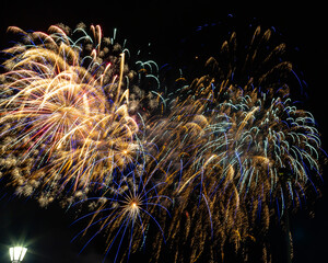 Fireworks in the night sky aftr a baseball game.