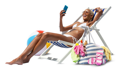 Happy woman at the beach on beach deck chair, sunbathing, uses mobile phone, isolated on white background, concept a summer beach holiday, online shopping, booking travel, and resorts accommodations
