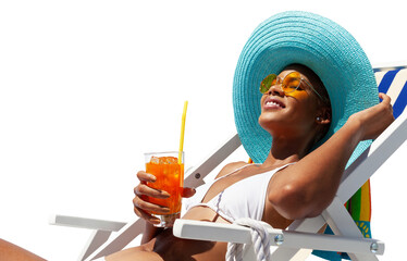 Happy woman is sunbathing on a beach deck chair, wearing sun hat and sunglasses, drinking a orange juice isolated on white background, concept of a summer beach holiday, booking travel and resort