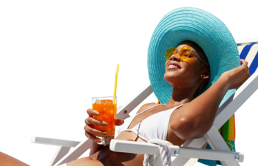 Happy woman is sunbathing on a beach deck chair, wearing sun hat and sunglasses, drinking a orange juice isolated on white background, concept of a summer beach holiday, booking travel and resort