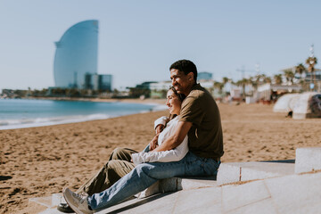 Fototapeta na wymiar Serene Barcelona beach moment with couple embracing by the Mediterranean sea