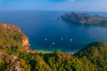 Aerial view Jungle with sunrise on Phi Phi with white yacht catamaran in Thailand. Concept trip Tourist boat in Thai travel.