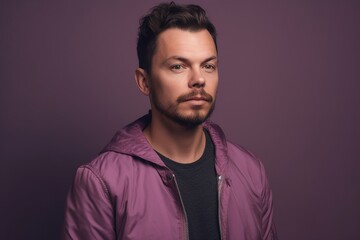 Obraz premium A man in a purple jacket is standing in front of a purple background