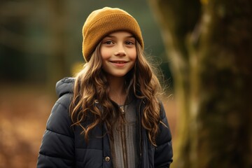 A young girl wearing a brown hat and a black jacket is smiling