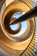 Incredible spiral geometric abstraction made of metal and bricks against a blue sky. Vertical photo