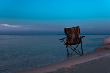 lonely chair in the middle of the sea and a beautiful sunrise