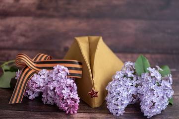Banner for May 9. Military uniform, cap with a star, St. George's ribbon and a bouquet of lilacs on...