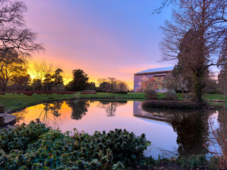 sunset at a country house with a lake and reflections