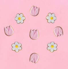 Gingerbread cookies in the shape of chamomile and tulip on the pink background. Top view. Flat lay.